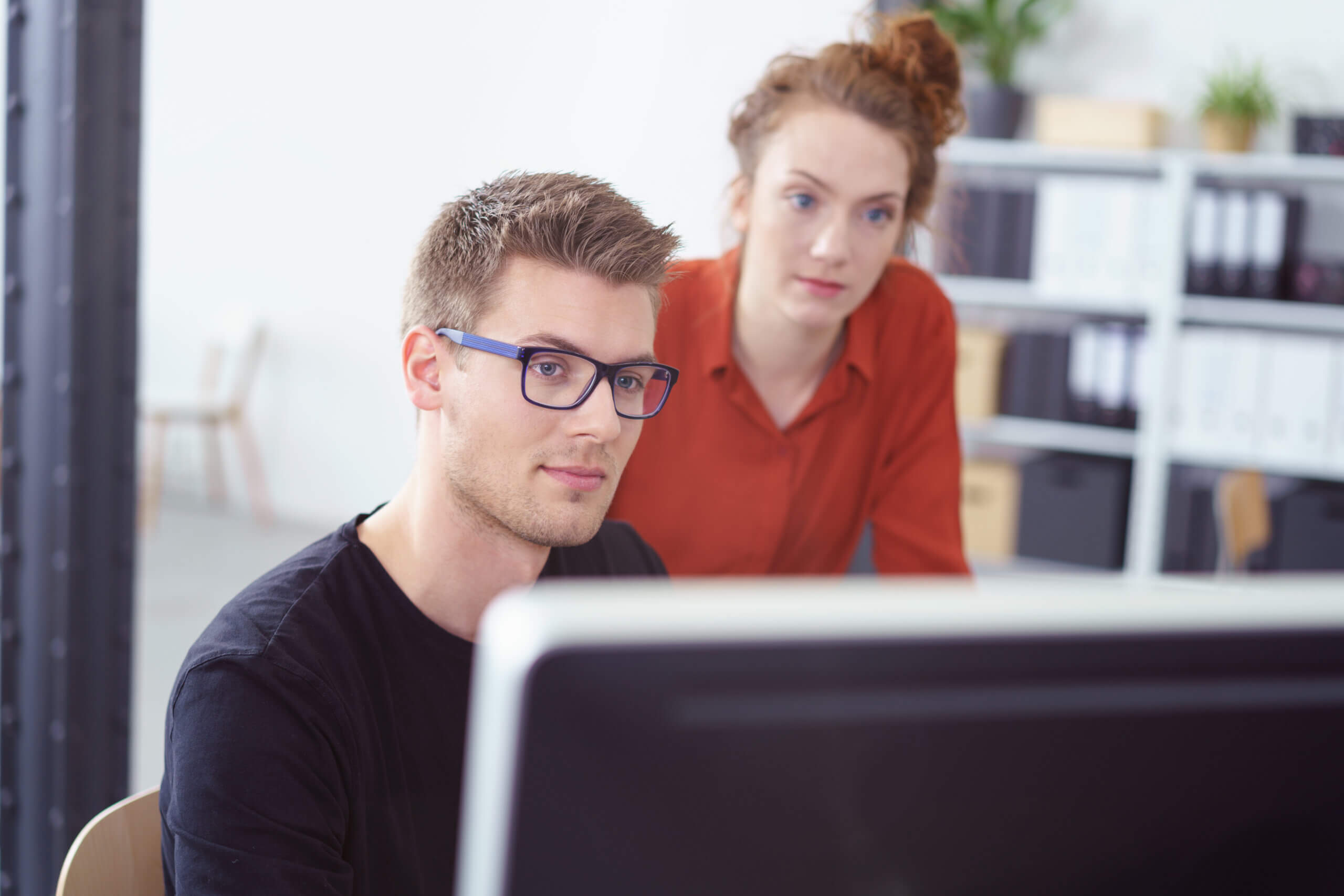 zwei Personen schauen auf einen Bildschirm